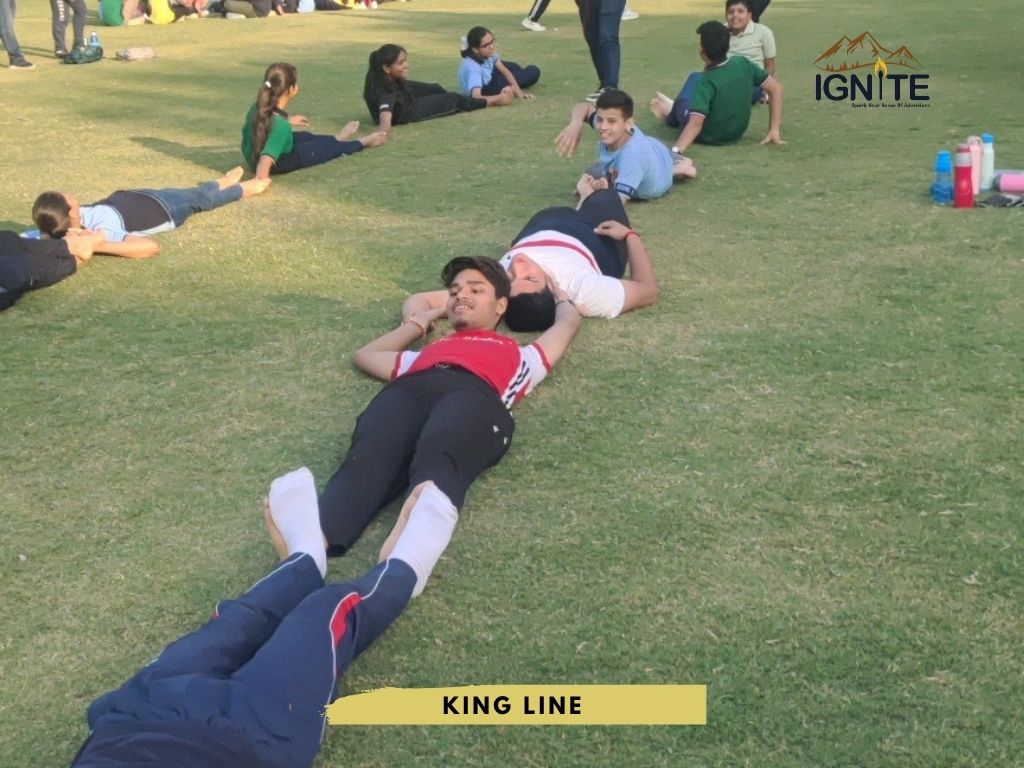 Students lying on the grass, forming a 'King Line' with their bodies