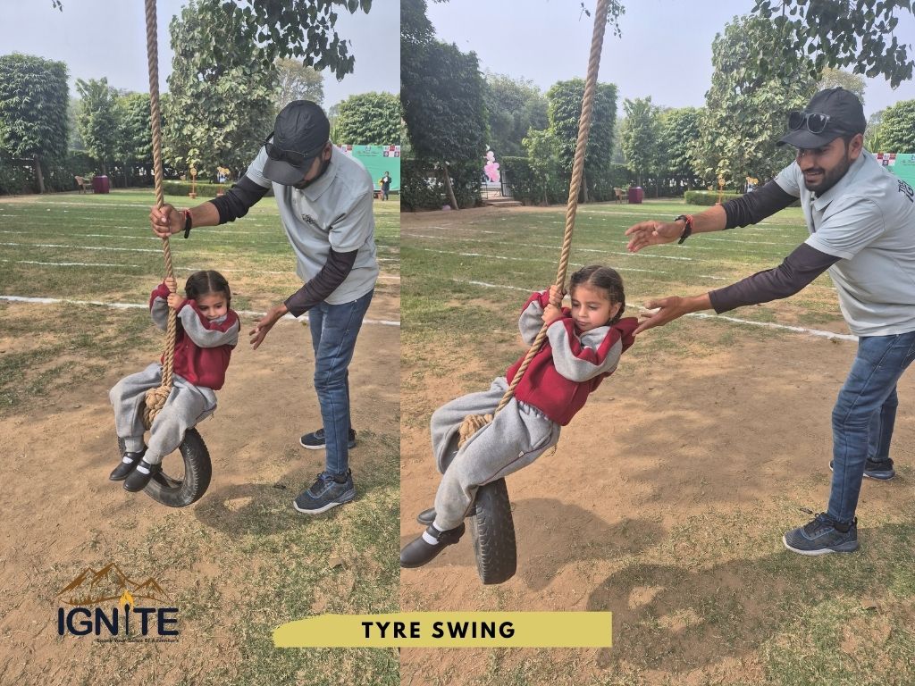 An instructor helping a young child on a tire swing