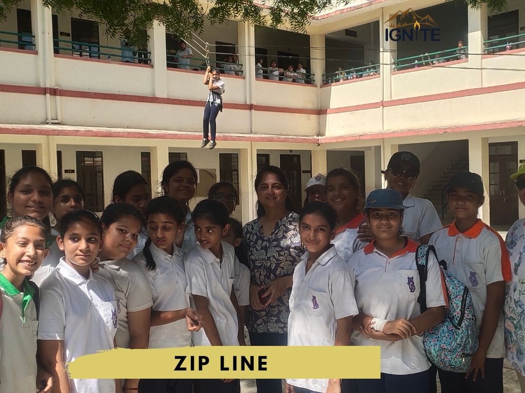Students posing with a zip line activity in the background