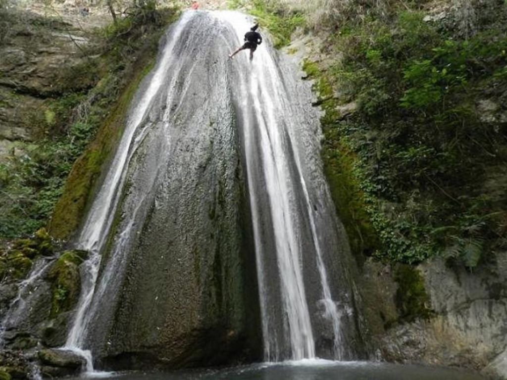 Person rappelling down a waterfall
